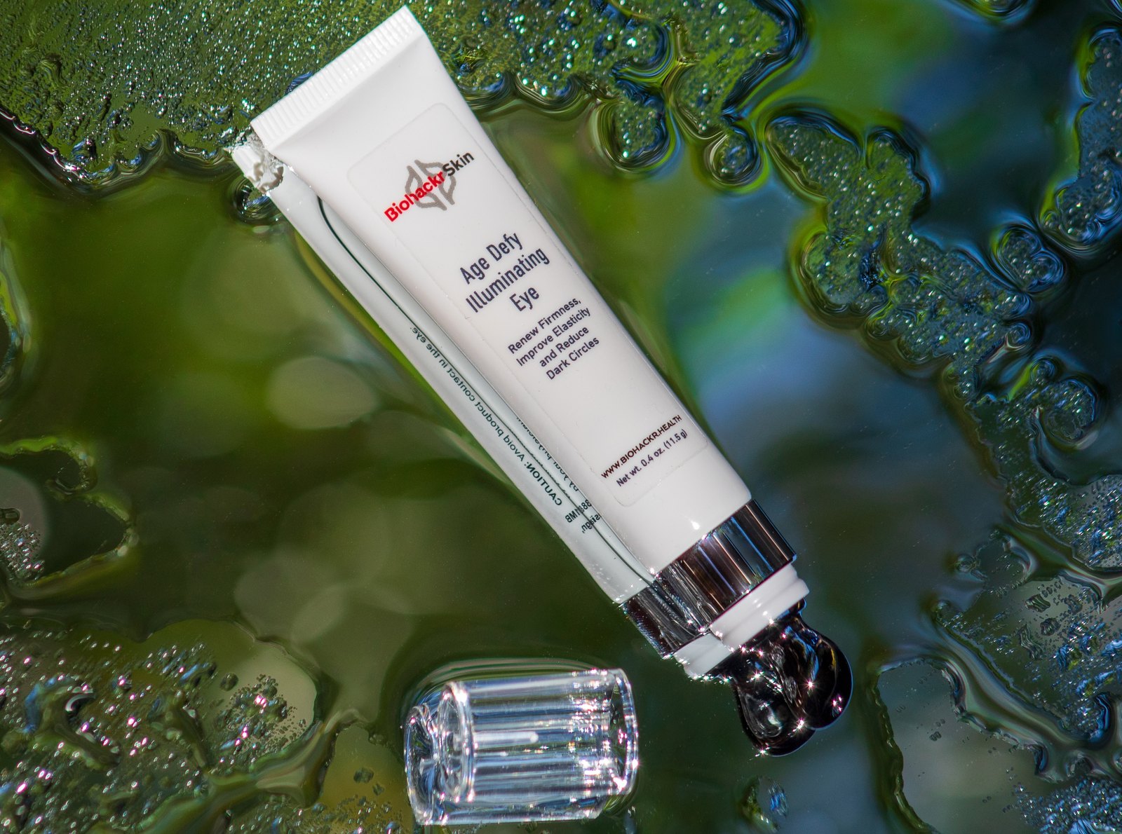 Biohackr Skin Age Defy Illuminating Eye on a wet botanical surface